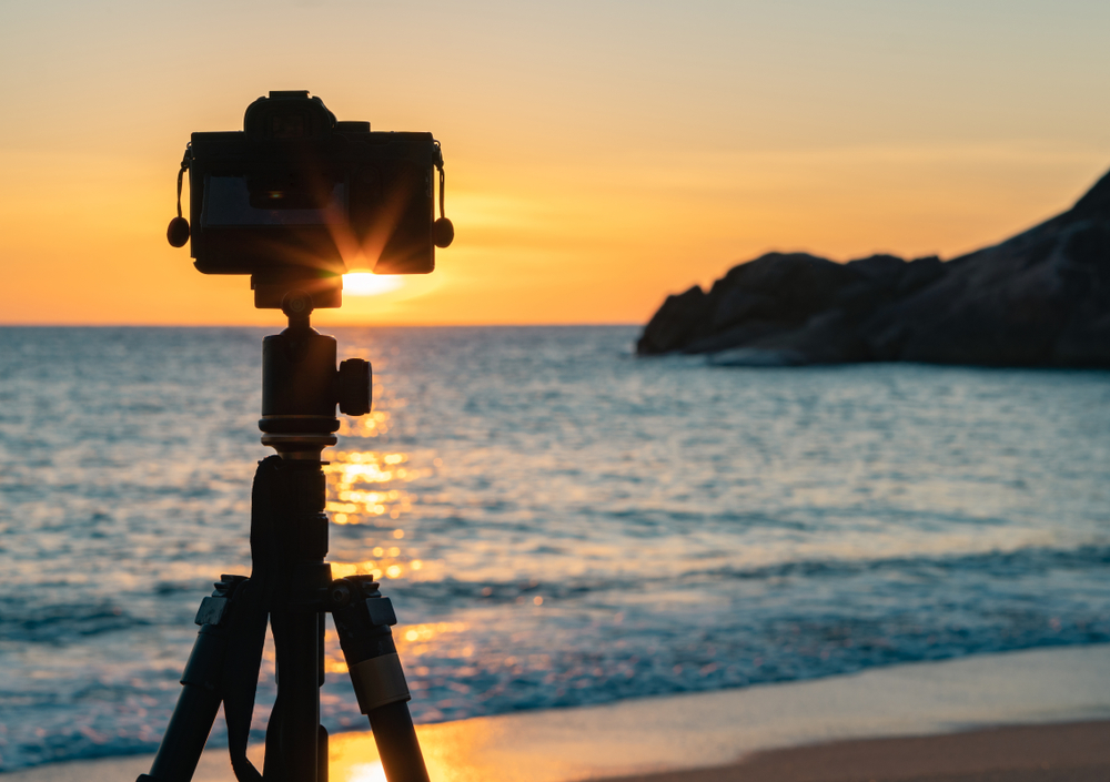 Camera,Standing,On,A,Tripod,On,The,Beach,Against,The